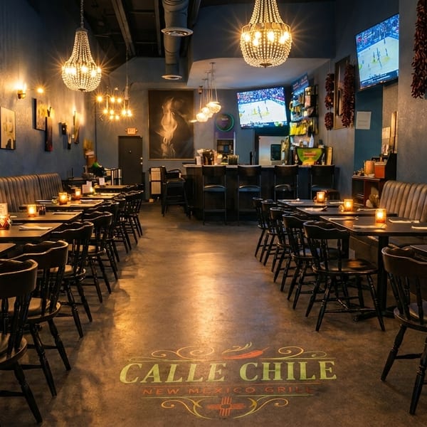 Interior of Calle Chile New Mexico Grill, showing dining tables, booths, a bar, and chandeliers.